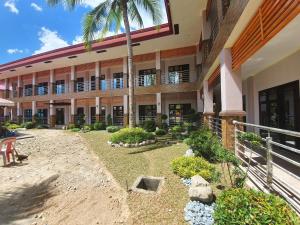 a building with a palm tree in front of it at Freedom Eco Adventure Park powered by Cocotel in Boac
