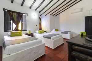 1 dormitorio con 2 camas, tocador y escritorio en Ayenda Corona Real, en Villavicencio