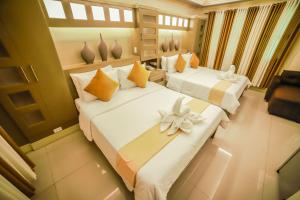 two beds in a hotel room with flowers on them at Villa Esmeralda Bryan's Resort Hotel and Restaurant in Palayan City +47 photos
