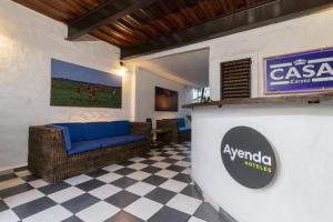 a lobby with a blue couch and a sign on a wall at Ayenda Corona Real in Villavicencio