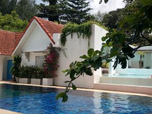 a house with a swimming pool next to a building at Ocean Breeze Resort Khaolak in Khao Lak