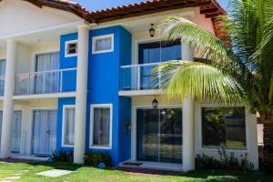 una casa azul con una palmera delante de ella en 7 Heaven Porto Seguro, en Porto Seguro