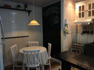a kitchen with a table and chairs and a chalkboard at Mini Casa na praia! in Bombinhas
