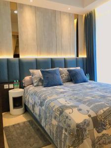 雅加達的住宿－Gold Coast PIK Sea View Apartments by LongeSuites，一间卧室配有一张蓝色床头板的床