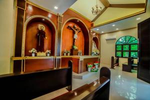 a church interior with a altar and a cross on the wall at Villa Esmeralda Bryan's Resort Hotel and Restaurant in Palayan City
