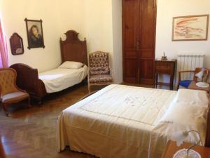 a bedroom with two beds and a chair in it at Villa Rosi in Cormòns