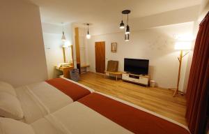 um quarto com uma cama e uma televisão de ecrã plano em 26-2 Simple Home Life em Yuli