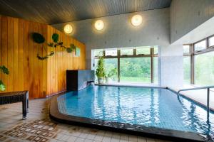 una gran piscina cubierta en un edificio en Asahidake Onsen Hotel Deer Valley, en Higashikawa