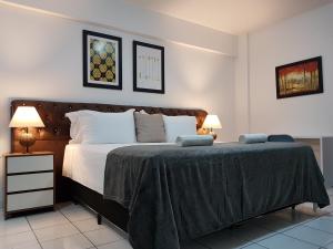 een slaapkamer met een groot bed en 2 lampen bij B & A Suites Inn Hotel - Quarto Luxo Âmbar in Anápolis