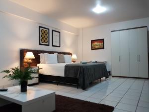 um quarto com uma cama, uma mesa e 2 candeeiros em B & A Suites Inn Hotel - Quarto Luxo Âmbar em Anápolis