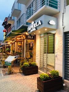 a store with tables and chairs in front of a building at Imperla Hotel in Isla Mujeres