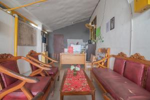 a living room with benches and a table with flowers on it at RedDoorz Syariah At Jalan cilik Riwut Kapuas in Kualakapuas
