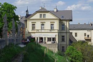 a large yellow house with people sitting outside of it at Vila U Varhanáře in Kutná Hora