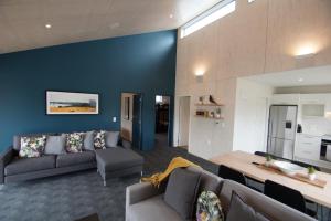 a living room with two couches and a blue wall at Apartments Hanmer Springs in Hanmer Springs