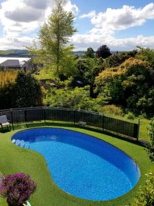 a swimming pool in a yard with a fence at VU Thermal Lodge - ADULTS ONLY MOTEL in Taupo
