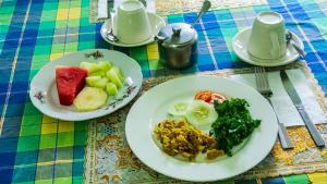 two plates of food sitting on a table at Chez Ophelia Cottage Apartments in Roseau