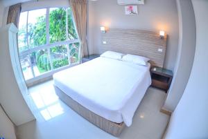 a bedroom with a white bed and a large window at ตำหนักวิลล่า 10 ห้องนอน พร้อมสระว่ายน้ำส่วนตัว in Pattaya South