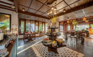 a restaurant with tables and chairs in a room at Zest Resort & Spa Hoi An in Hoi An