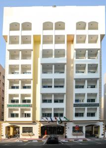 ドバイにあるGreen House Hotel Suites & Apartmentのバルコニー付きの白い大きな建物