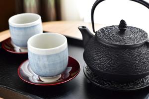 two cups and a teapot on a table at SH by the square hotel Kyoto Kiyamachi in Kyoto