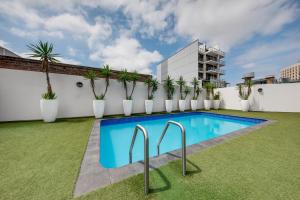 a swimming pool on the roof of a building with plants at Vibe Hotel Sydney in Sydney