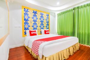 曼谷的住宿－OYO 410 Diamond Boutique Hostel，一间卧室配有一张带绿色窗帘的大床