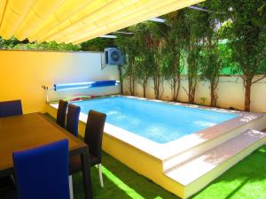 una piscina en un patio trasero con mesa y sillas en PortoHouse, en Oporto
