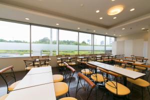 - une salle à manger avec des tables, des chaises et de grandes fenêtres dans l'établissement Hotel Econo Taki, à Ōka