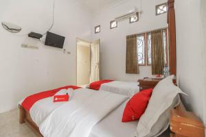 En eller flere senge i et værelse på RedDoorz Syariah near Watervang Lubuk Linggau 2