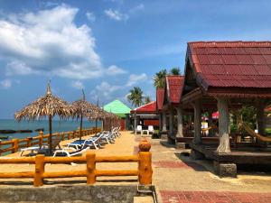 ein Resort mit Liegestühlen und Sonnenschirmen am Strand in der Unterkunft Blue Andaman Lanta Resort in Ko Lanta