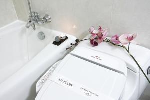 a white bath tub with a toilet with flowers on it at Hotel Paragon in Busan