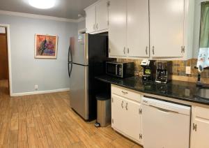 a kitchen with white cabinets and a stainless steel refrigerator at The Peacock House in San Antonio