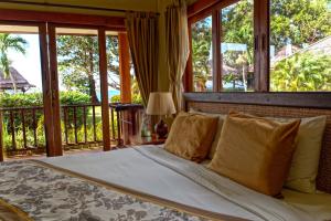 Schlafzimmer mit einem Bett mit Fenstern und einem Balkon in der Unterkunft Anahata Resort in Lipa Noi