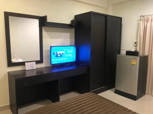 um quarto com uma secretária, um computador e um frigorífico em Me Apartment em Ban Talat Rangsit