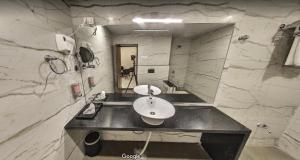 a bathroom with a sink and a mirror at Hotel Bharat in Kota