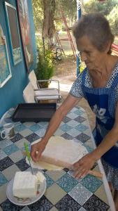 Una donna che taglia una torta sopra un tavolo di Manos STUDIOS & APARTMENTS a Skopelos Town