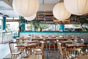 um restaurante com mesas e cadeiras de madeira e luzes em The Great Escape Bellevue Hill em Sidney