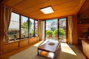 a living room with a table and large windows at i-STAY(Hanahana) in Ishigaki Island