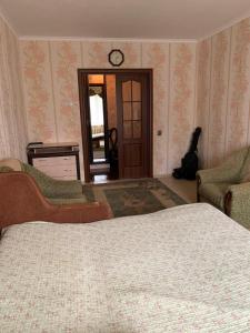 ein Schlafzimmer mit einem Bett und einer Uhr an der Wand in der Unterkunft 131 проспект Добровольского Хорошая 3-х комнатная квартира в Одессе in Odessa