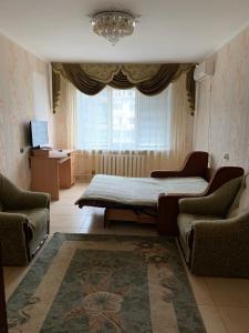 1 Schlafzimmer mit einem Bett, 2 Stühlen und einem Fenster in der Unterkunft 131 проспект Добровольского Хорошая 3-х комнатная квартира в Одессе in Odessa