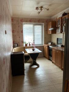 eine Küche mit einem Tisch in der Mitte in der Unterkunft 131 проспект Добровольского Хорошая 3-х комнатная квартира в Одессе in Odessa