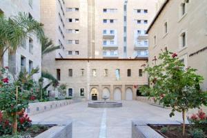 a courtyard with a fountain in front of a building at 104 - King David Residence - Jerusalem-Rent in Jerusalem