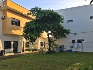 a building with a tree in front of it at Tulip Apartment in Ormoc