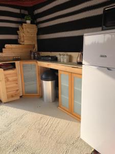 a kitchen with wooden cabinets and a white refrigerator at אוהל לוט in Arad