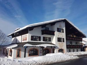 un gran edificio con nieve en el techo en Pension Zum Schmidbäcker, en Freyung