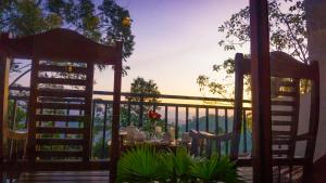 a patio with a table and chairs on a deck at Shining Green View in Ella