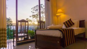 a bedroom with a bed and a balcony with a view at Shining Green View in Ella