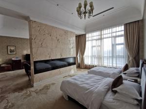 a hotel room with two beds and a fireplace at ACFTU Model Worker Harbin Center for Skills Exchange(Former Heilongjiang Sun Island Garden Hotel) in Harbin