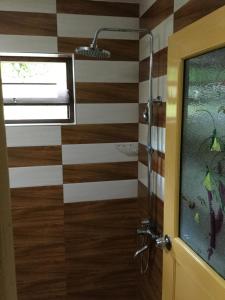 a bathroom with a shower with wooden floors and a window at Sea Close Inn in Ahangama +41 photos