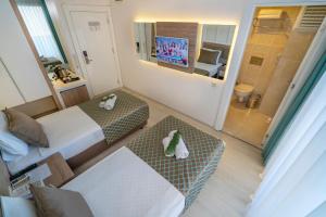 um pequeno quarto com 2 camas e uma televisão em Kleopatra Life Hotel em Alanya